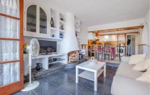 a living room with a white couch and a fireplace at Awesome Home In Tossa De Mar With Wifi in Tossa de Mar