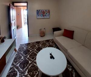 a living room with a white couch and a table at Staycation with Karimi in Embu