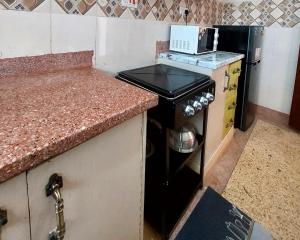 a kitchen with a stove with a laptop on top of it at Staycation with Karimi in Embu