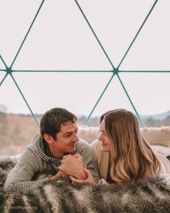 Un uomo e una donna stesi su un divano di Wadi Rum Luxurious Camp View a Wadi Rum