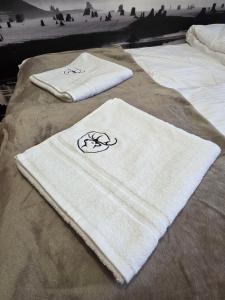 two white towels sitting on top of a bed at Polana Jelenia Głowa in Wambierzyce