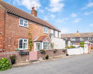 une image d'une maison en briques dans l'établissement Winterton Sea Sanctuary, Hot Tub & Log Burner by the Dunes, à Winterton-on-Sea