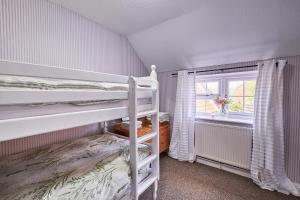 une chambre avec deux lits superposés et une fenêtre dans l'établissement Winterton Sea Sanctuary, Hot Tub & Log Burner by the Dunes, à Winterton-on-Sea