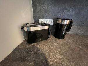 two coffee machines sitting on a counter next to an electrical outlet at Schöne Maisonette 4 Zimmer mit Garten in Rodgau