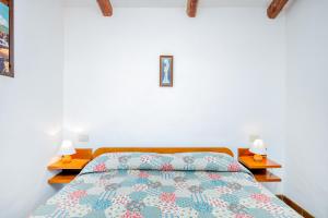una camera da letto con un letto con due comodini e due lampade di Villetta Amelie a Baja Sardinia a Cala Bitta Altre 16 foto