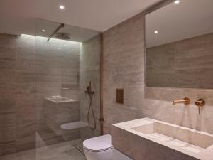a bathroom with a shower and a toilet and a sink at Nur Riviera Aparthotel in Athens +8 photos