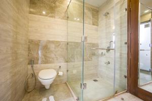 a bathroom with a toilet and a glass shower at SaffronStays Barlowganj Villa in Mussoorie