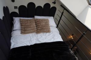 a bed with two pillows on top of it at Manchester City Centre Duplex in Manchester