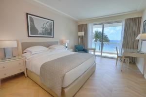 ein Schlafzimmer mit Bett und Blick auf das Meer in der Unterkunft Mövenpick Hotel Beirut in Beirut