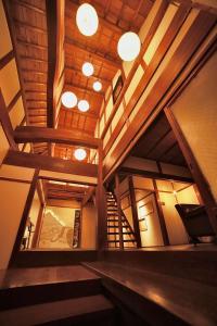 a large room with wooden ceilings and wooden stairs at Osakaya Hotel & SAUNA in Kaizuka