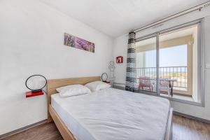 una camera da letto con un letto e una grande finestra di Appartement face à la mer a Soulac-sur-Mer