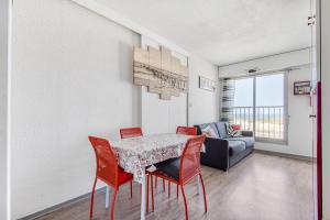 una sala da pranzo con tavolo, sedie e divano di Appartement face à la mer a Soulac-sur-Mer