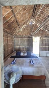 a large bed in a room with a fan at Raja Ampat Jousuba Homestay in Minyaifuin