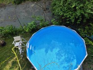 a large blue object sitting on the grass with a chair at Channel-Appartement cosy avec piscine, jardin & nature aux portes de Paris in Saint-Maurice