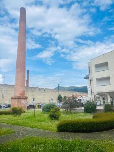 een oude fabriek met een hoge toren op de achtergrond bij La Ciminiera in Prato