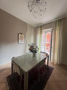 a dining room with a glass table and a chandelier at CASA TIO PIERO Centrale accogliente e confortevole in Asti