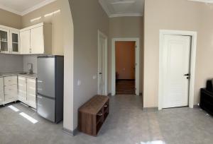 a kitchen with a stainless steel refrigerator and a stool at LakeSide in Gabala