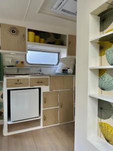 une cuisine avec des armoires en bois et un évier dans l'établissement Castlemaine Gardens Vintage 60's Caravan, à Castlemaine