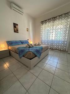 a bedroom with a bed and a large window at Soulmondo Mare Apartment in Campomarino