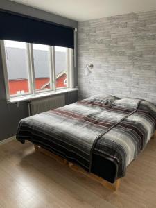 a bed in a room with a brick wall at Hus på bondgård in Gunnarskog