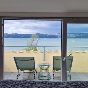 two chairs and a table on a balcony with a view of the water at Perbes Dreams in Perbes +11 photos