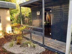 a wooden outhouse with a wooden porch at heerlijk vakantie huis Lovely holiday home in Lanaken +5 photos