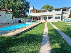 a backyard with a swimming pool and a house at Casa Recanto do Vale Condominio in Guapimirim