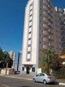 a car parked in front of a tall building at Suíte Lari in Caldas Novas