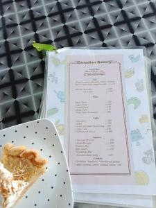 a piece of pie on a plate next to a menu at Corn Village Cottage in Lakhwār