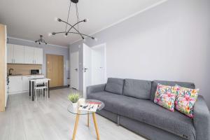 sala de estar con sofá gris y cocina en Przestronny Apartament w Zielonej Okolicy Parking by Noclegi Renters, en Sosnowiec