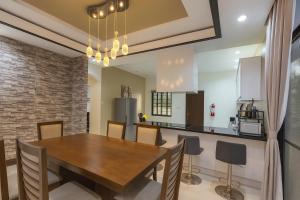 a kitchen and dining room with a wooden table and chairs at Hanella's Place in Bacong