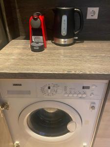a washing machine sitting on a counter with a coffee pot at Cosy 2-room apartment center Self check-in in Rīga