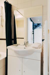 un bagno con un lavandino bianco e uno specchio di Maison Cœur Historique du Vieux Lille de 98m2 a Lille Altre 30 foto