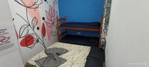 a small bedroom with a bunk bed with blue walls at Hostel Casarão do Surf in Bertioga