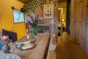 a wooden table with a vase of flowers on it at Hoeve Linnerveld in Merum