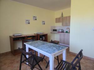 a kitchen with a table with chairs and a counter top at Noce i dnie in Białogóra