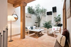sala de estar con mesa, sillas y plantas en Home Deco Marenya House Costa Brava, en La Tallada