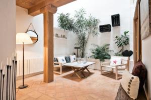 a living room with a table and chairs and plants at Home Deco Marenya House Costa Brava in La Tallada