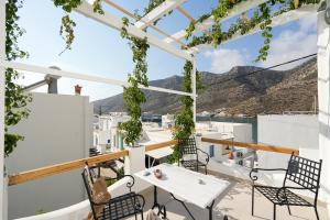 a balcony with white tables and chairs and a view of the mountains at Podotas Group in Kamares