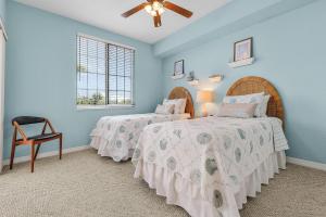 Dos camas en un dormitorio con paredes azules. en Fun and Magical Beach Escape - Amazing Beach Condo - Roelens, en Fort Myers Beach 19 fotos más