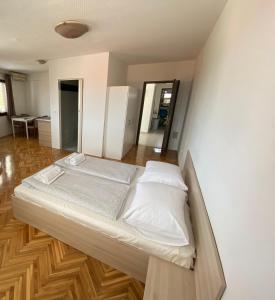 a bed with white sheets and pillows in a room at Apartments Deli in Vrsi