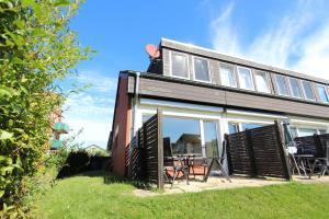 a house with sliding glass doors and a table outside at MeerMoment in Langeoog