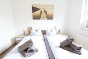 two beds in a room with towels on them at Inselschatz in Langeoog