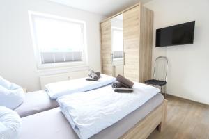 a bedroom with two beds and a flat screen tv at Inselschatz in Langeoog