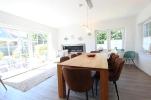 a dining room with a wooden table and chairs at Ferienhaus Stefanie 1 in Langeoog +14 photos