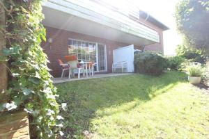 a patio with a table and chairs in a yard at MeeresZeit in Langeoog +9 photos