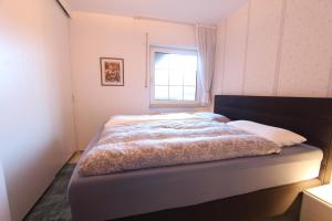 a bed in a bedroom with a window at MeeresZeit in Langeoog
