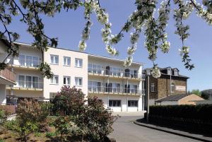 an exterior view of a white apartment building at Landhotel Sanct Peter in Bad Neuenahr-Ahrweiler