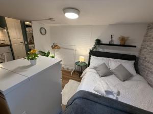 a bedroom with a white bed and a brick wall at Studio for City Breaks in Balham in London