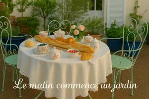 Una mesa con un mantel blanco y croissants encima. en Les oiseaux de passage - chambre d hôtes, paisible, en Gaillon